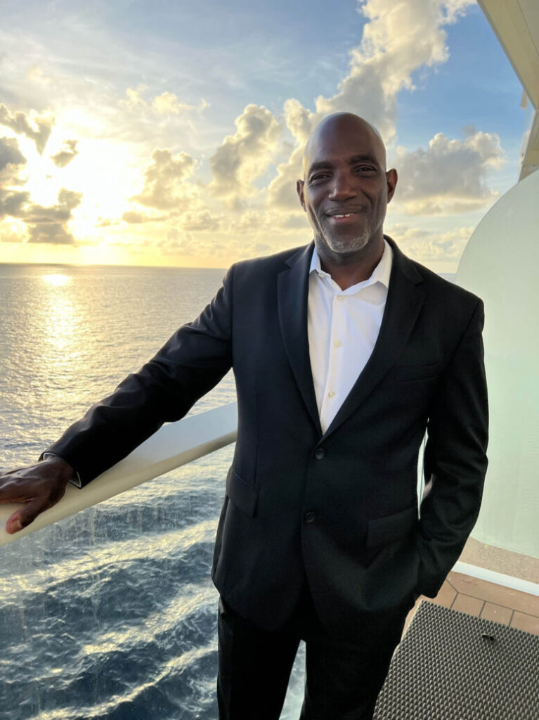 Kitwana Akil in suit on cruise ship balcony